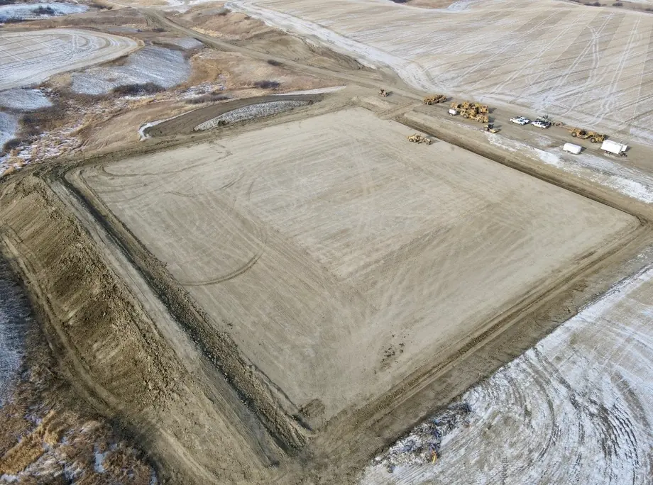 An Arkon Earth Construction pad build seen from the air in the snow, with equipment working one corner