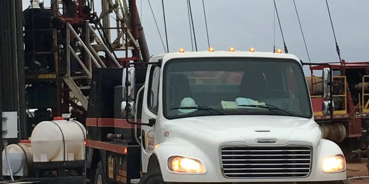 A Castle truck at a workover rig with hands on the floor