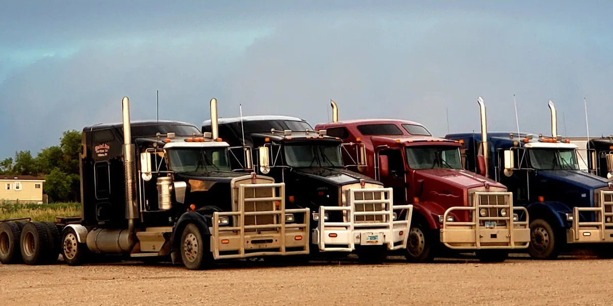 A row of StateLine trucks parked under a storm sky