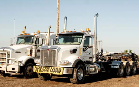 TTK winch trucks with an oversize load banner
